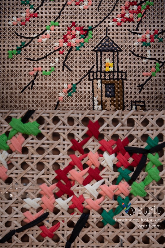 Detail of the lantern room, black thread in open columns around a small stitched flame